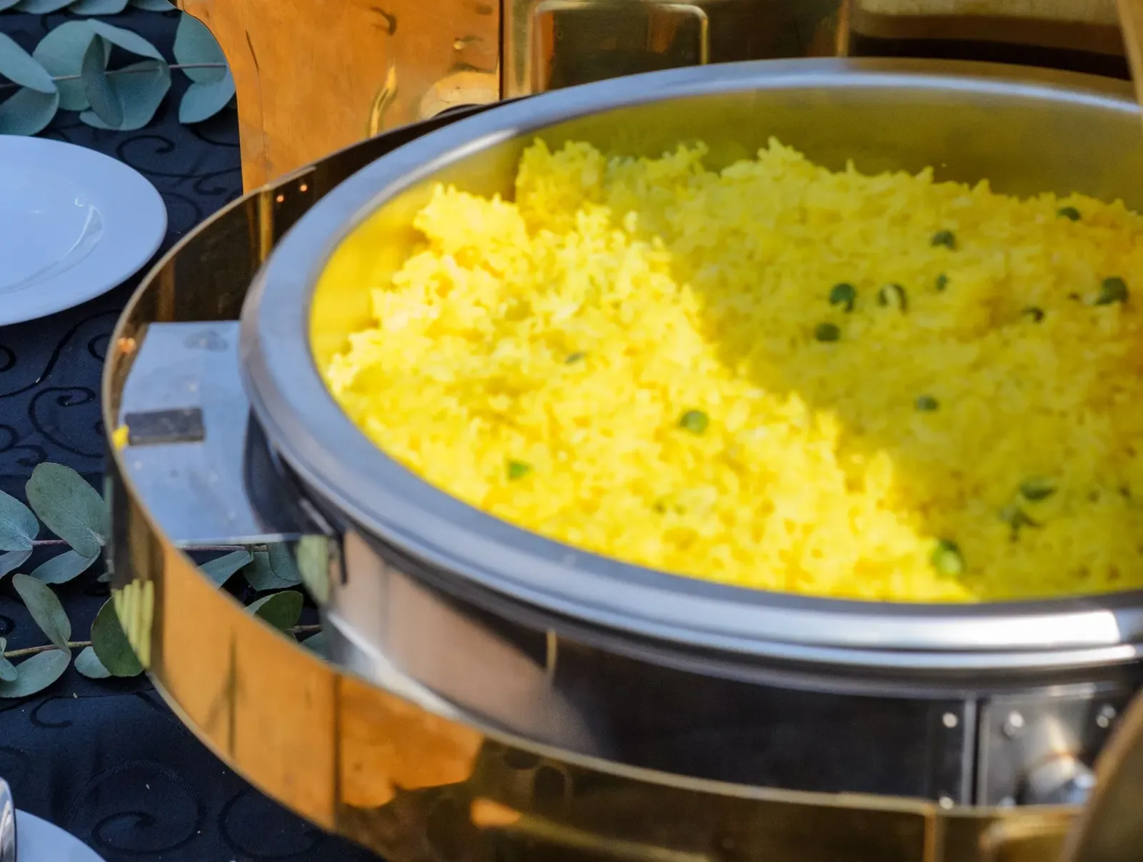 Yellow rice with peas in a chafing dish at a catered event