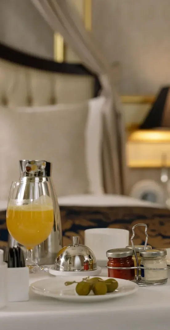 Orange juice, jam and olives on a breakfast tray in a hotel room